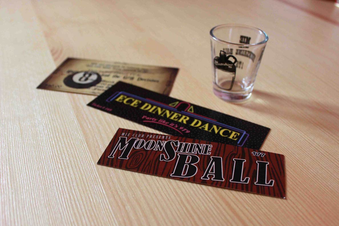 Various printed event tickets laid out alongside a decorated shot glass