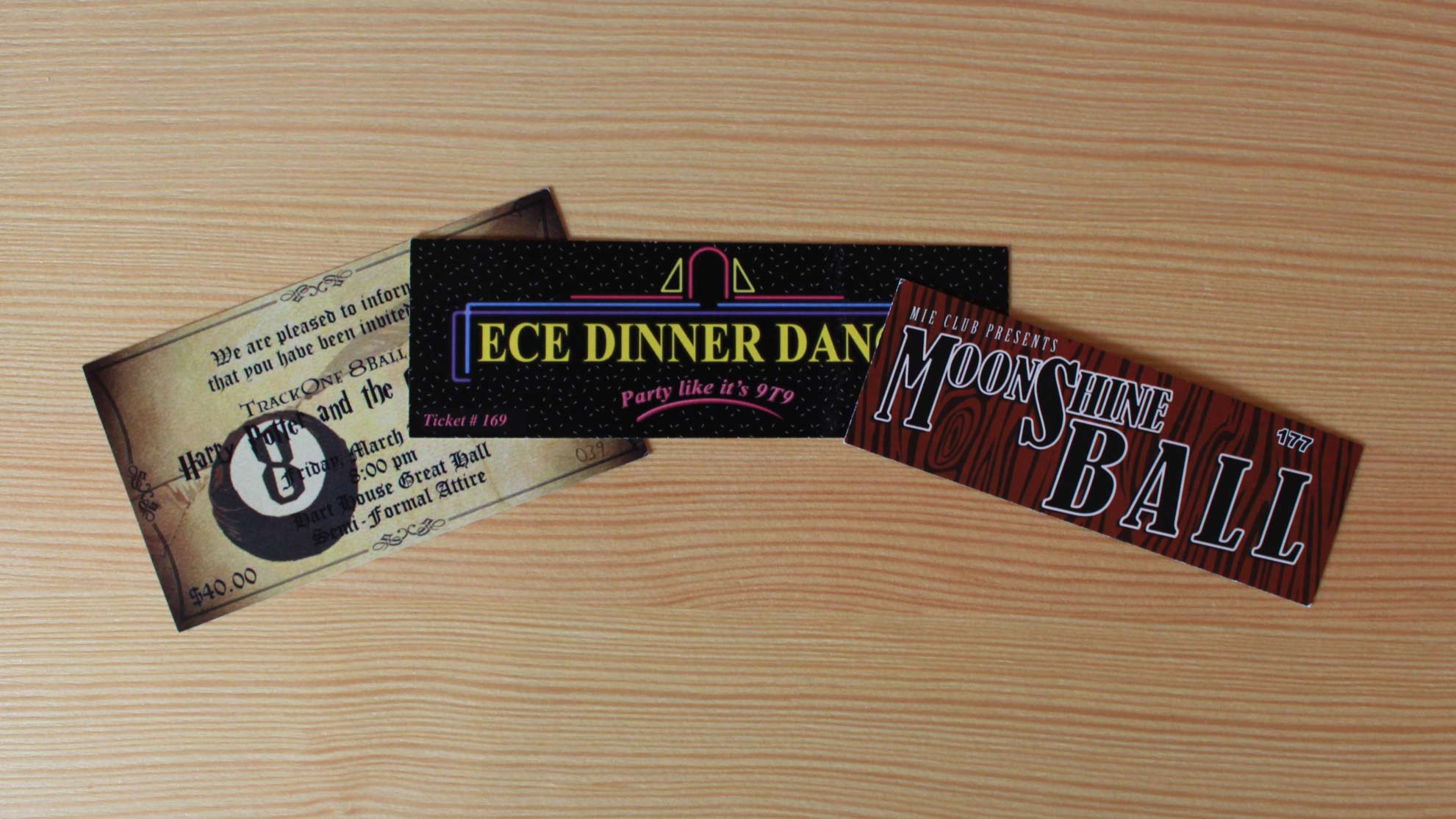 Three printed event tickets laid out on a wood table